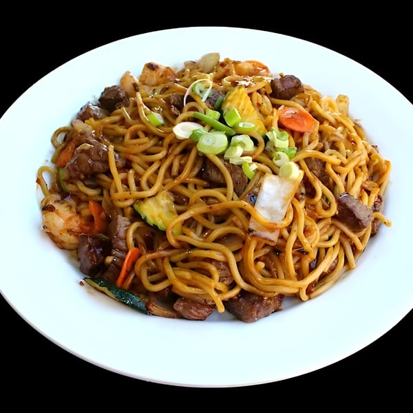 Hibachi noodles with beef, shrimp, and vegetables, garnished with green onions on a white plate.