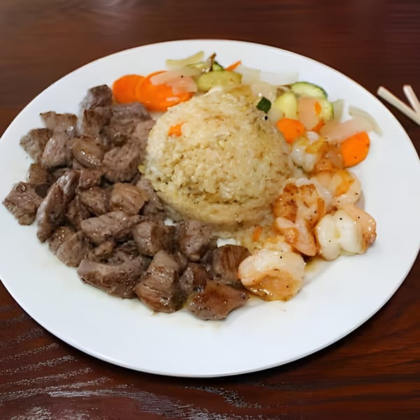 Hibachi steak, shrimp, fried rice, and mixed vegetables on a white plate.